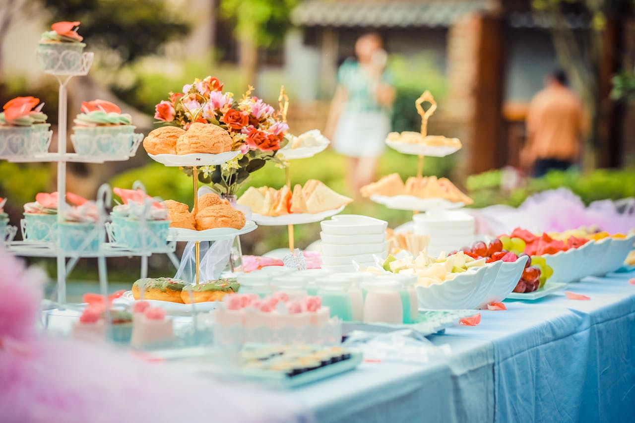 portfolio-04 A vibrant outdoor buffet table showcasing an array of colorful pastries and fruits, perfect for parties.